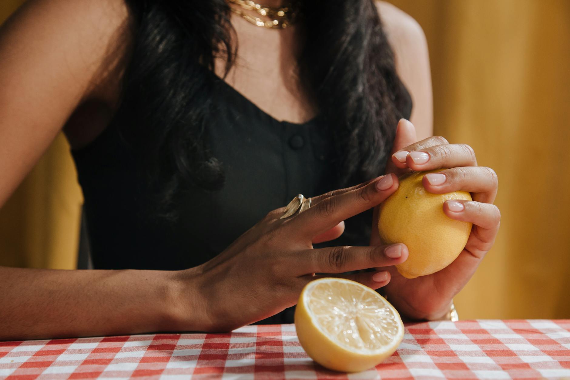 A close-up of hands holding a sleek clitoral vibrator against a soft background