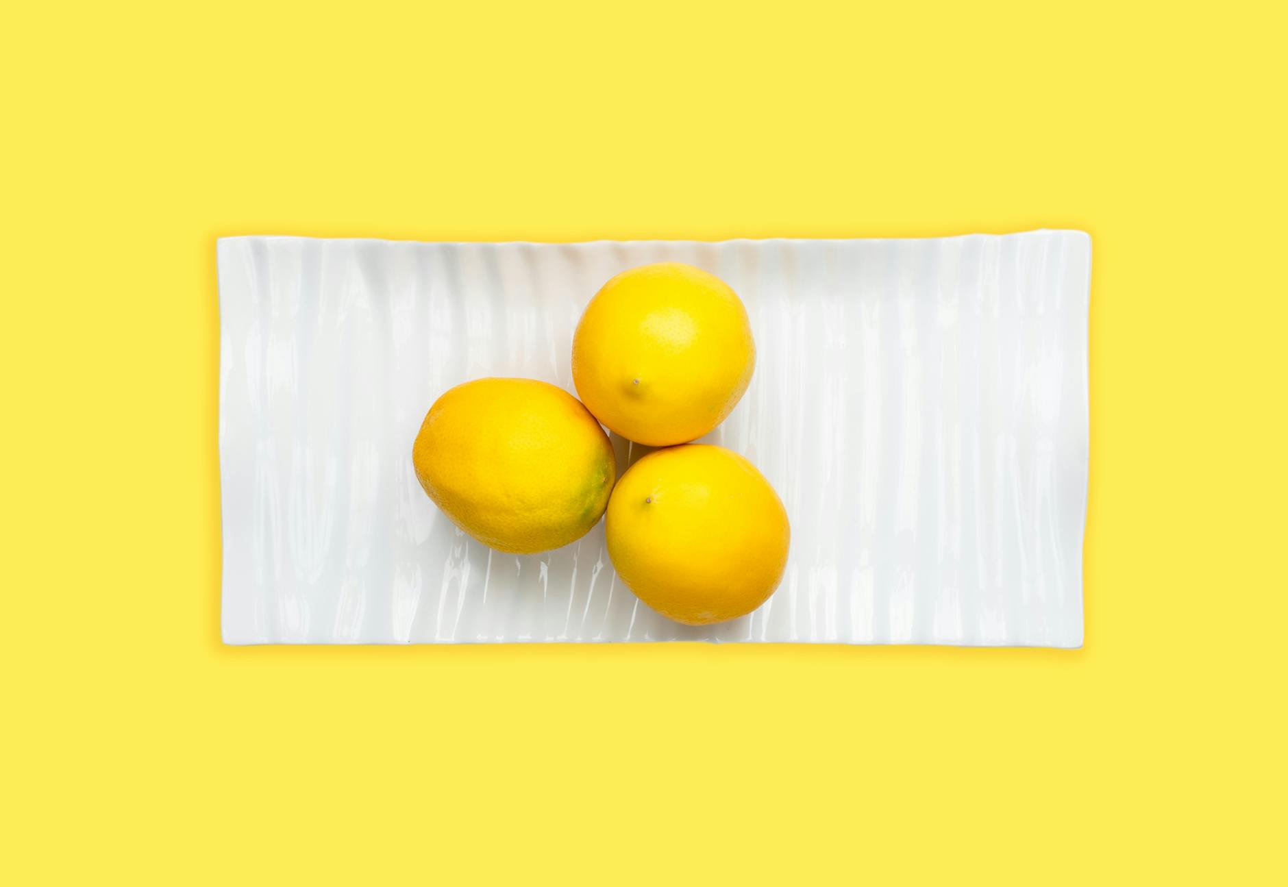 Fresh lemons arranged on a white plate, symbolizing natural freshness and vitality