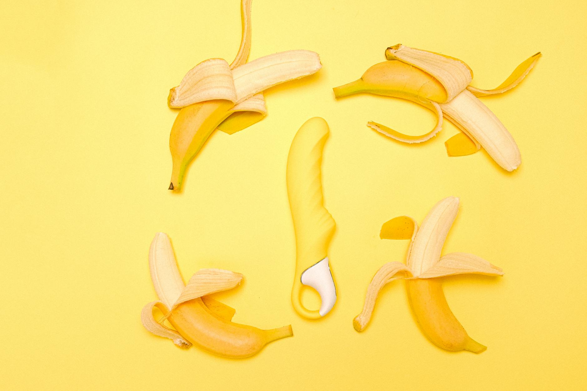 Yellow lemon vibrator surrounded by fresh lemons on yellow background