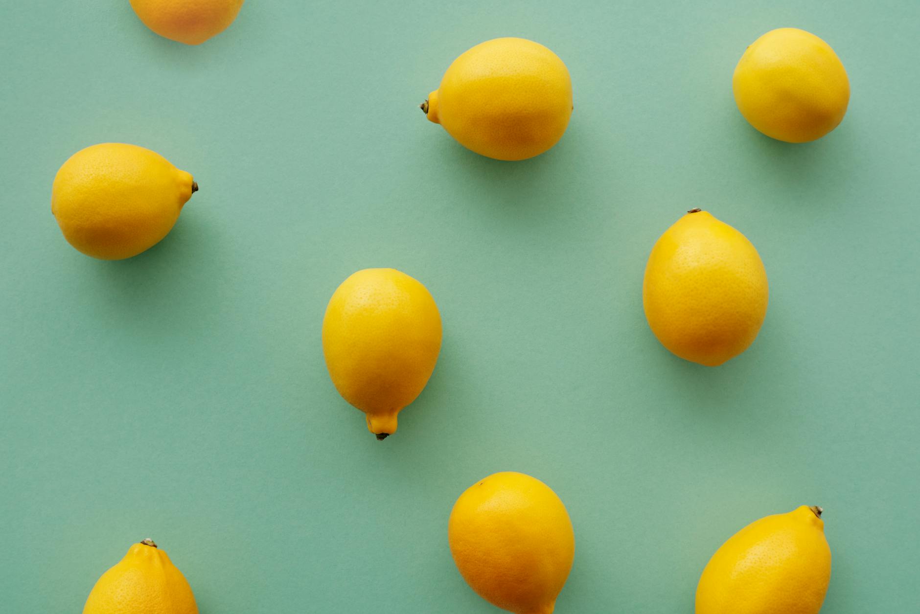 A yellow lemon vibrator surrounded by fresh yellow fruit on a bright background