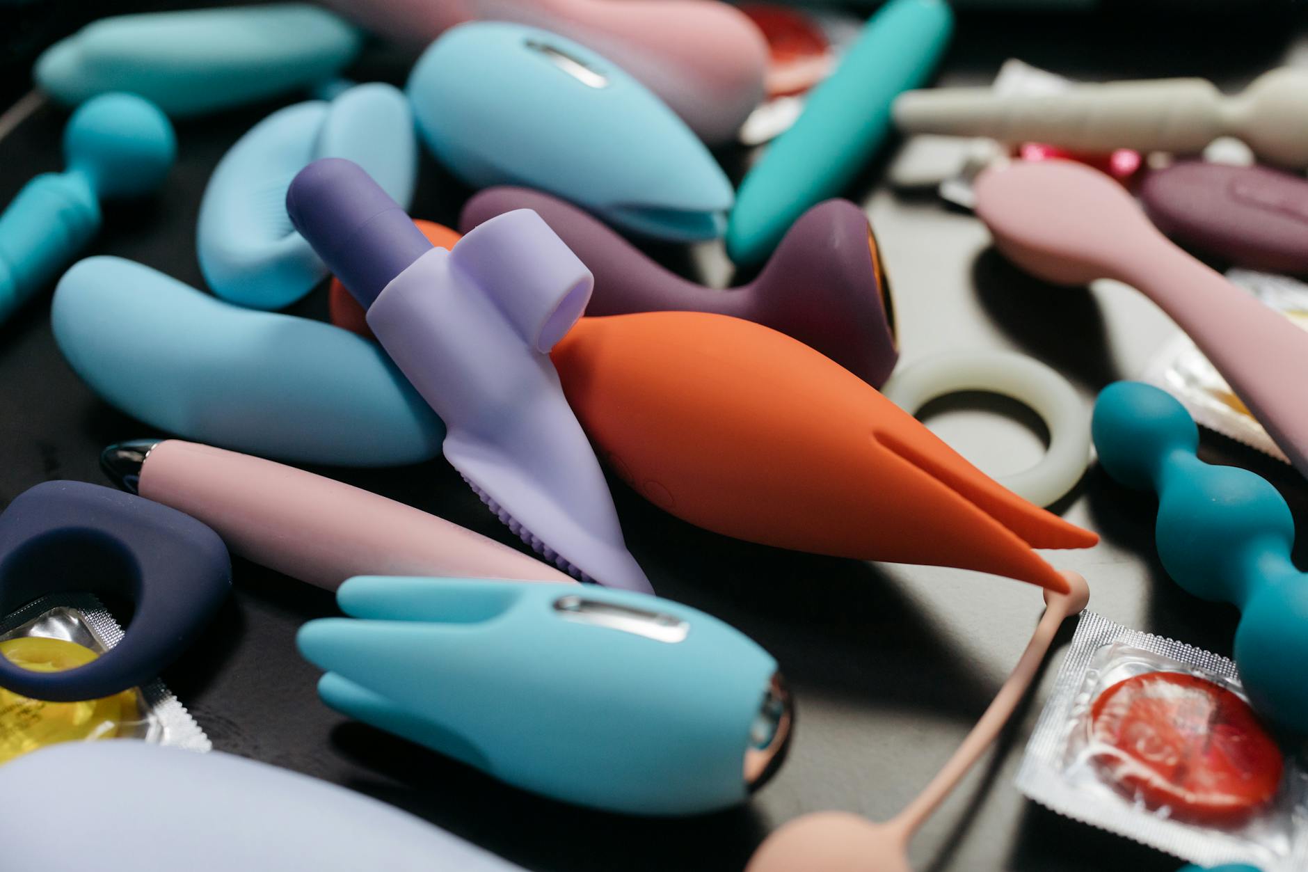 An assortment of vibrant clitoral vibrators displayed in close-up, including lemon-shaped designs.