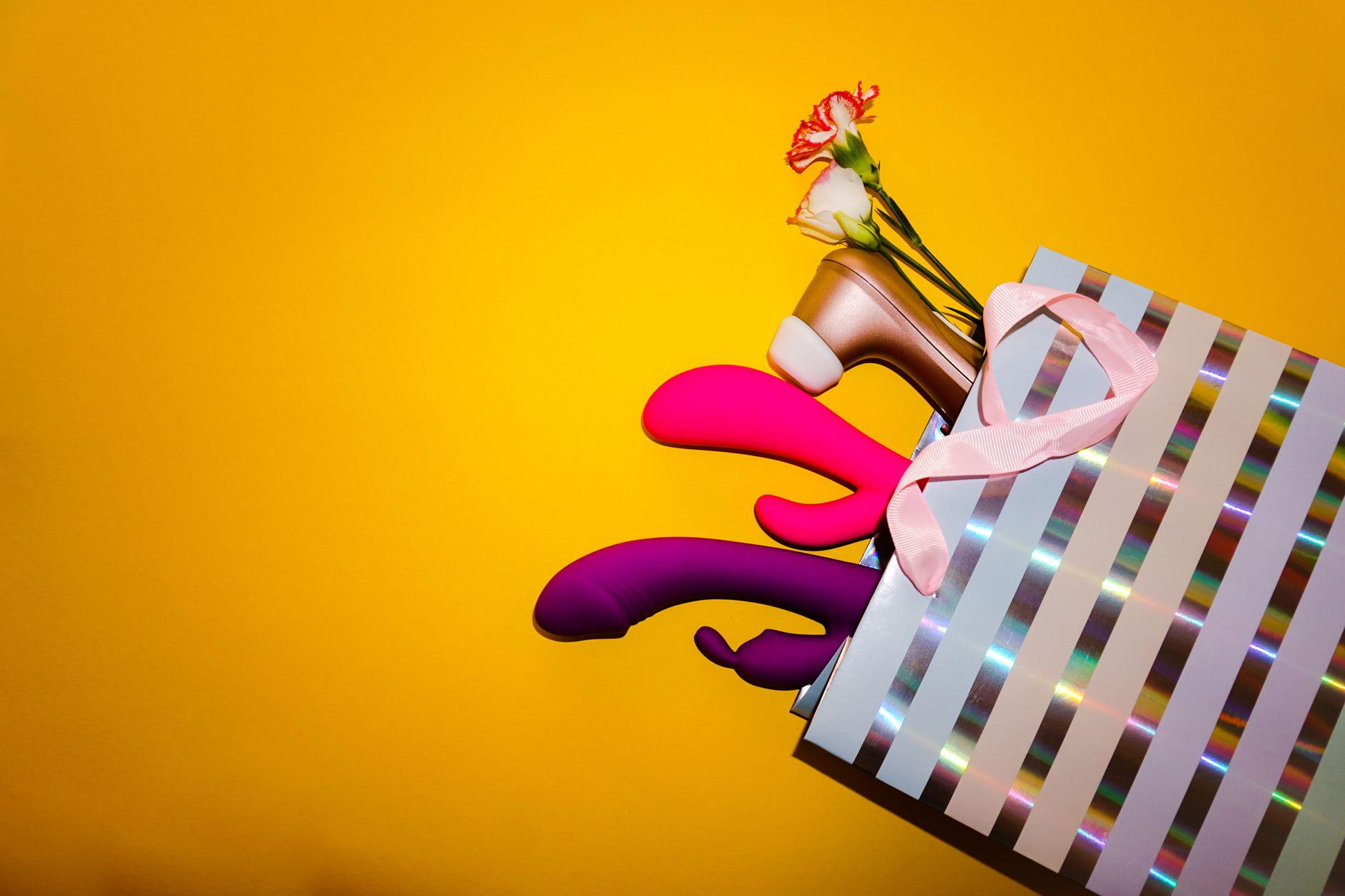 A hand holds a fresh lemon against a bright yellow background, representing the refreshing citrus design of lemon clitoral vibrators