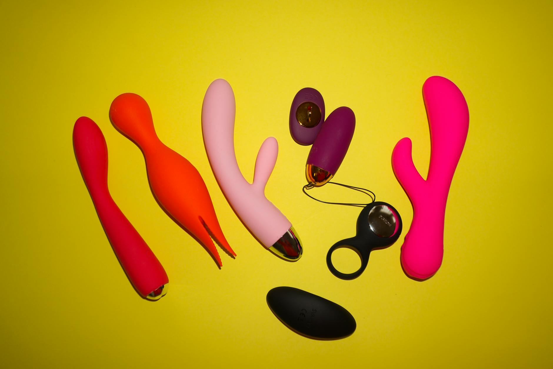 Woman holding silicone vibrators in a contemplative expression